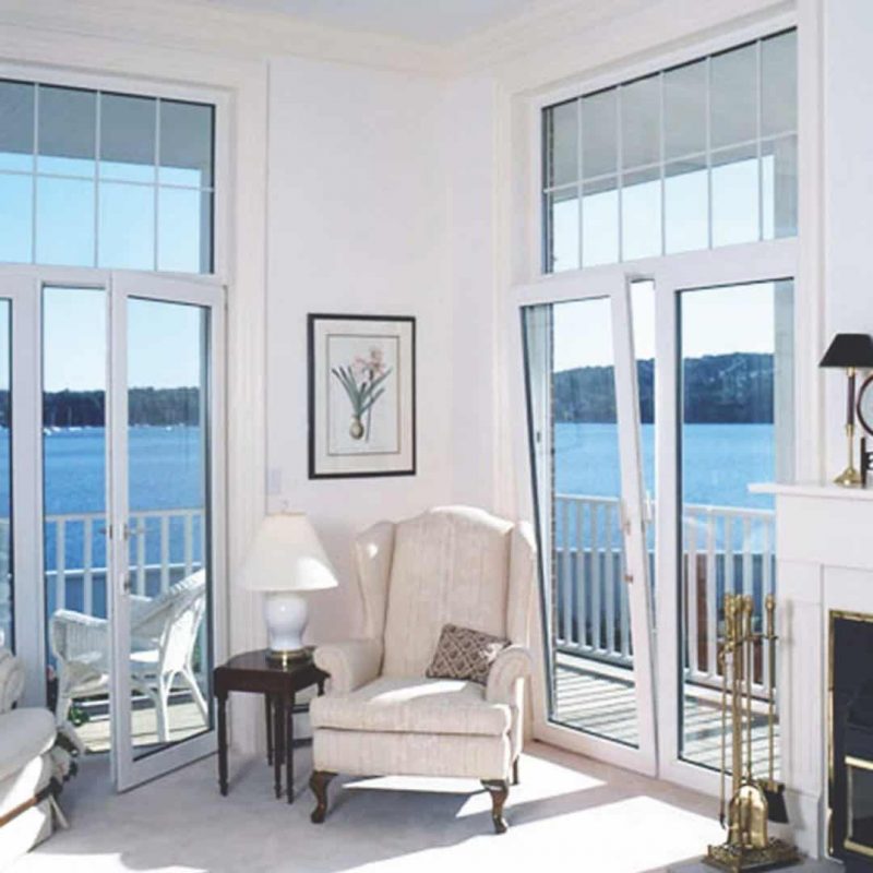 A white room with a white chair with tilt and turn windows.